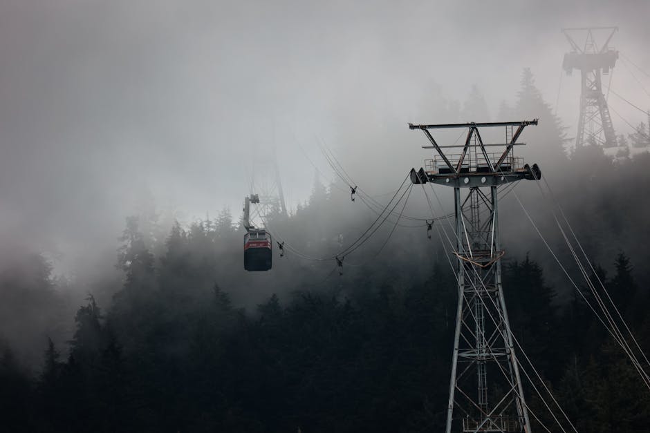 Gondola traveling through misty forested mountains in Vancouver, creating a moody atmosphere.